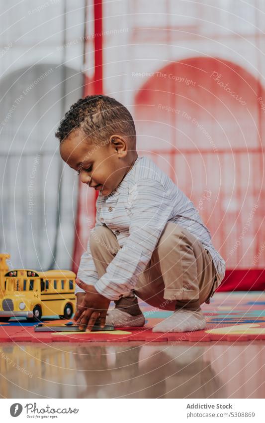 Niedlicher kleiner Junge spielt mit Spielzeug Kleinkind spielen sich[Akk] entspannen Teppich farbenfroh zu Hause niedlich bezaubernd Kind schwarz Afroamerikaner
