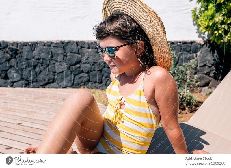 Kind mit Sonnenbrille auf Liege liegend Mädchen Sonnenbad Bräune Badeanzug ruhen Sommer Stil trendy Strohhut sich[Akk] entspannen farbenfroh lässig Garten