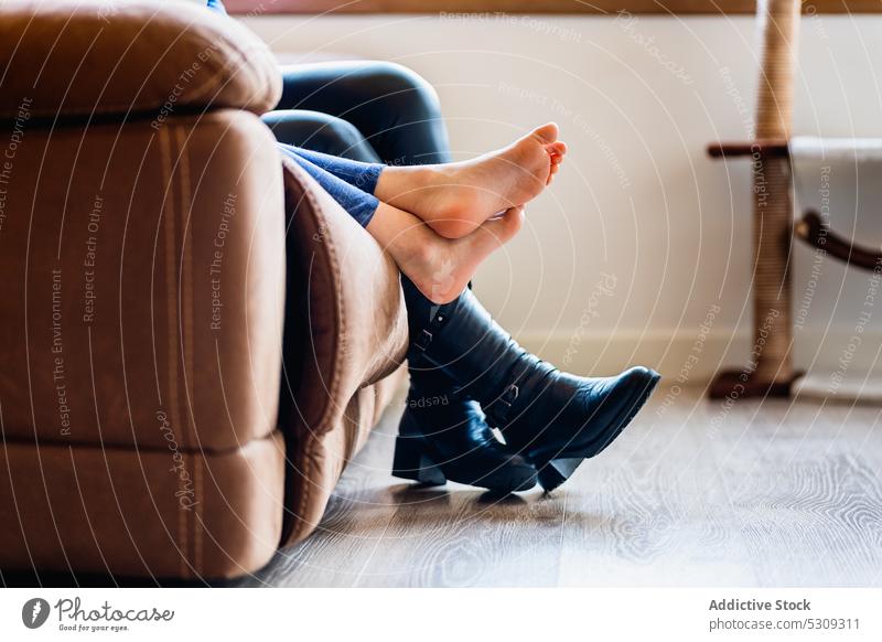 Beine von anonymen Menschen auf dem Sofa sitzend Barfuß ruhen Fuß sich[Akk] entspannen Kälte Wohnzimmer Stiefel Liege Komfort Leder räkeln heimwärts