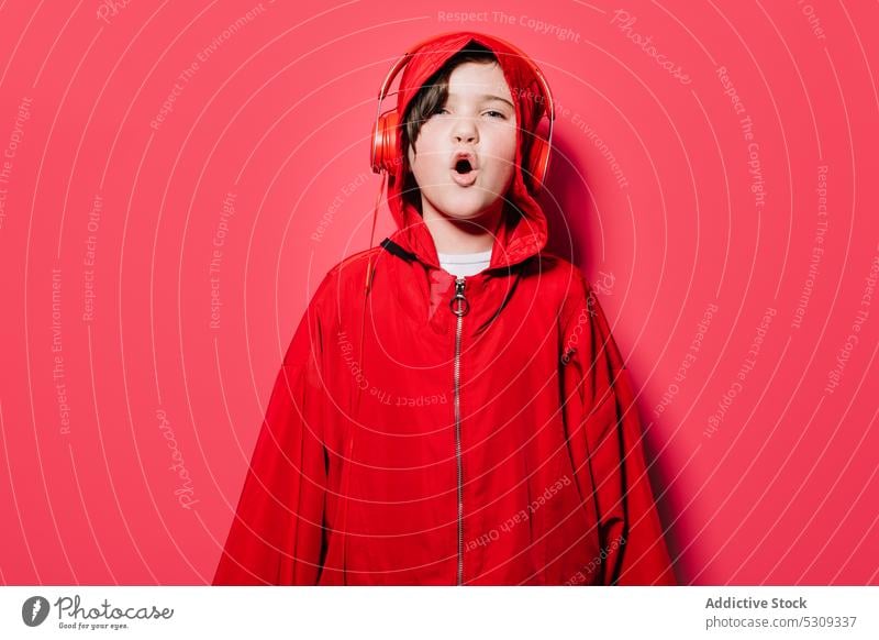 Stylisches junges Mädchen in rotem Kapuzenpulli mit Kopfhörern zuhören Musik Stil trendy lässig selbstbewusst modern Kind Klang singen hell Farbe laut Gesang