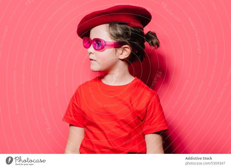 Mädchen in rotem Freizeithemd und Baskenmütze schaut weg Stil lässig Kind trendy Outfit Mode Brille Studioaufnahme Porträt wenig Sonnenbrille cool vereinzelt