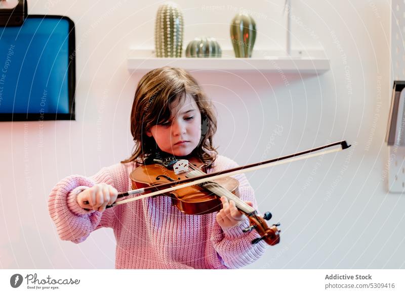 Niedliches Kind übt Geige im Schlafzimmer Mädchen spielen Musik Fähigkeit Kindheit Talent Bett Musiker bezaubernd Instrument fiddlestick Melodie Schnur brünett