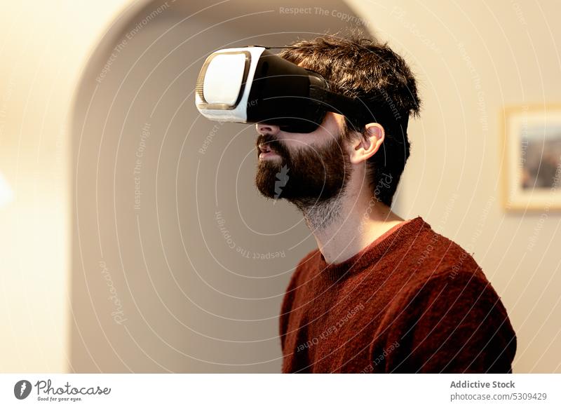 Staunender Mann mit VR-Brille an der Wand Virtuelle Realität Schutzbrille benutzend Technik & Technologie Erfahrung unterhalten Headset Apparatur Gerät Spieler