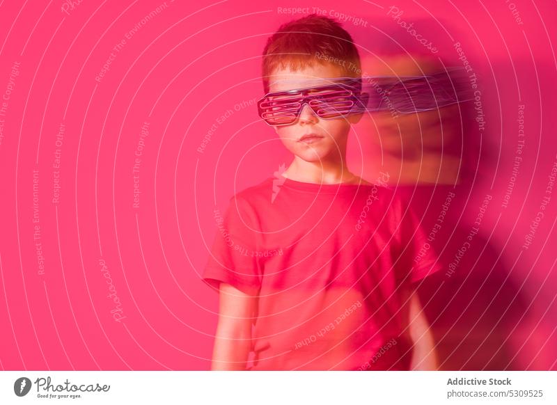 Ernster Junge mit futuristischer Brille schaut in die Kamera Stil Kind farbenfroh selbstbewusst hell modern Farbe ernst lebhaft Hemd pulsierend trendy Outfit