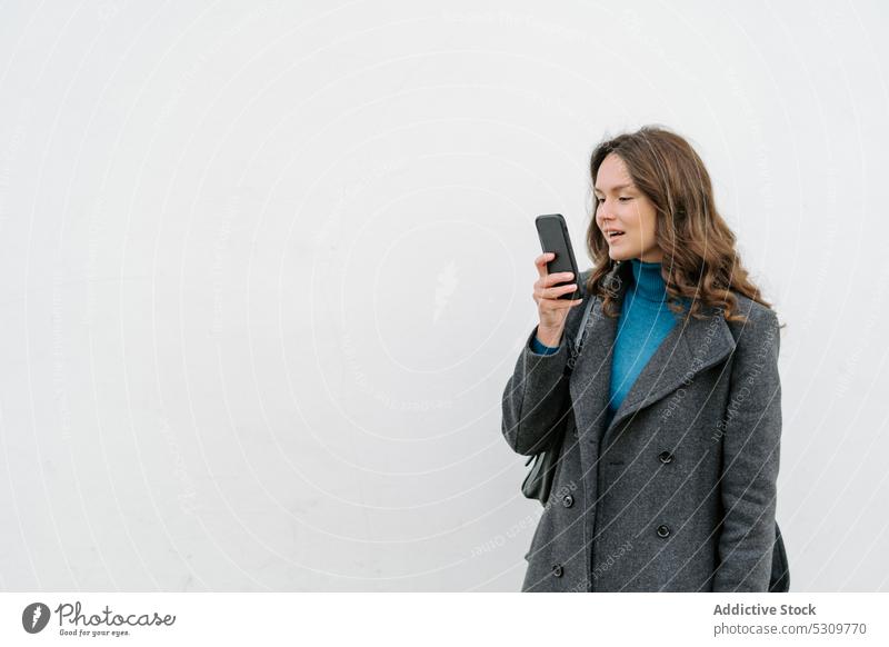 Frau, die eine Sprachnachricht auf einem Mobiltelefon aufnimmt, auf weißem Hintergrund Smartphone Nachricht benutzend Glück Mantel Apparatur Gerät Aufzeichnen