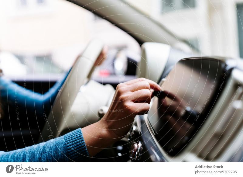 Anonyme Frau fährt Auto und benutzt das Armaturenbrett Fahrer Laufwerk PKW Lenkrad digital modern benutzend Schaltfläche Musik Anzeige Presse Gerät Apparatur