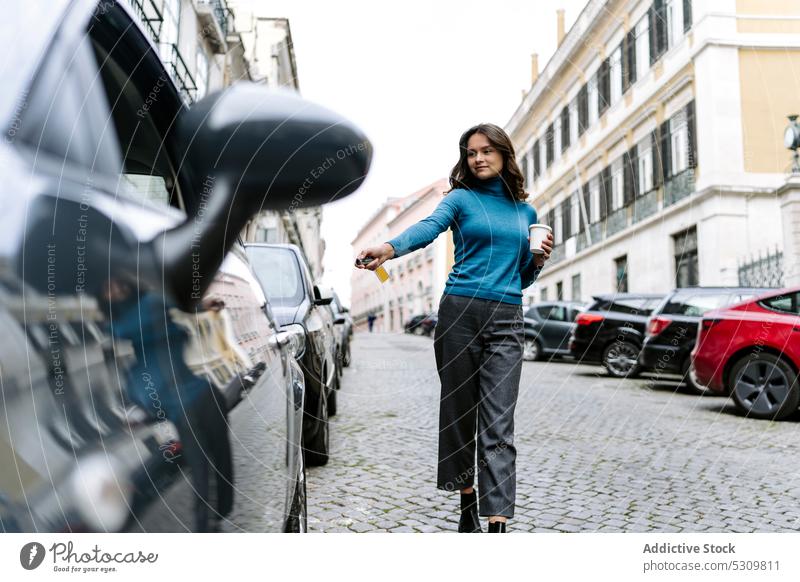 Junge Frau schließt Auto mit elektronischem Schlüssel ab positiv PKW Automobil elektronischer Schlüssel Schloss Großstadt Straße Fahrzeug Kaffee Imbissbude