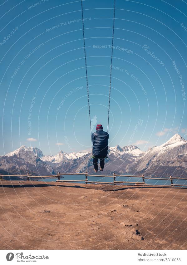 Unbekannter Reisender schwingt an einem Seil in sandigem Gelände an Bergen und Fluss Mann hängen Urlaub Berge u. Gebirge Natur Tourismus Blauer Himmel Tourist