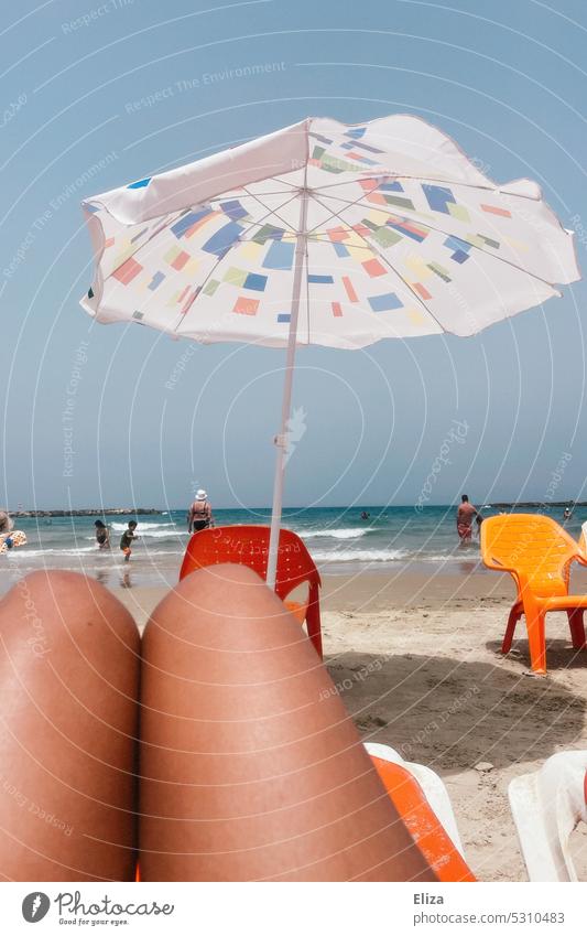 Oberschenkel am Strand mit Sonnenschirm im Badeurlaub Urlaub Meer Menschen Sommer orange Plastikstühle Ferien & Urlaub & Reisen Sommerurlaub sonnig Strandtag