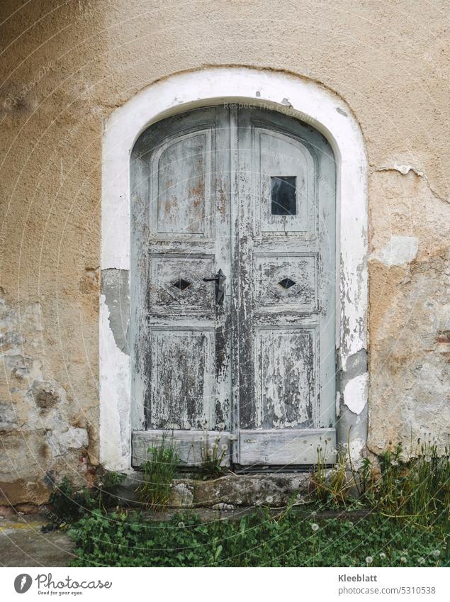 Traurige alte Tür im Torbogen - altes Gemäuer Doppeltor Doppeltür zugeklappt alter Torbogen alte Mauer Fassade Architektur Gebäude Außenaufnahme Gras Verfall