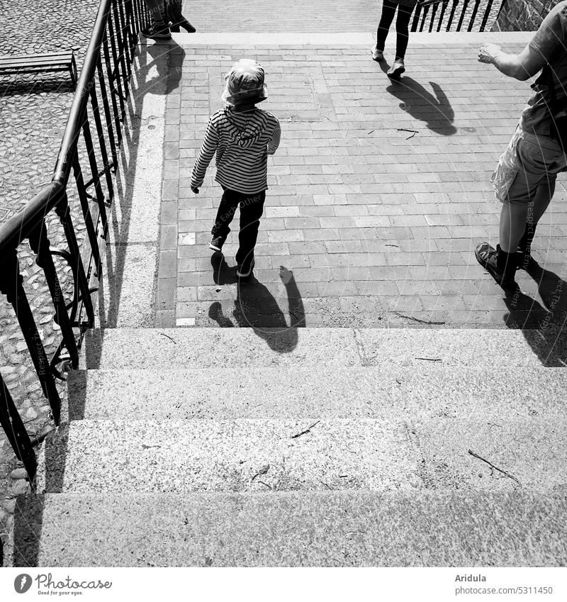 Große und kleine Menschen laufen eine breite Treppe runter s/w Kinder Erwachsen Familie Gruppe Stufen Stein Pflastersteine gehen spazieren Spaziergang Ausflug