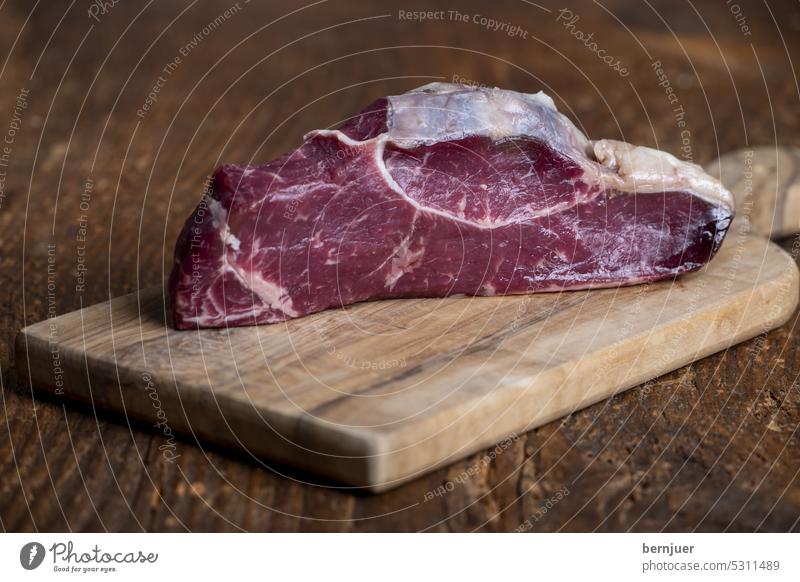 rohes Steak auf einem Schneidebrett Ribeye Fleisch Holz Grill Essen Kräuter mittel Rindfleisch Brett Filet Rosmarin Angus gekocht Salz Beefsteak gegrillt
