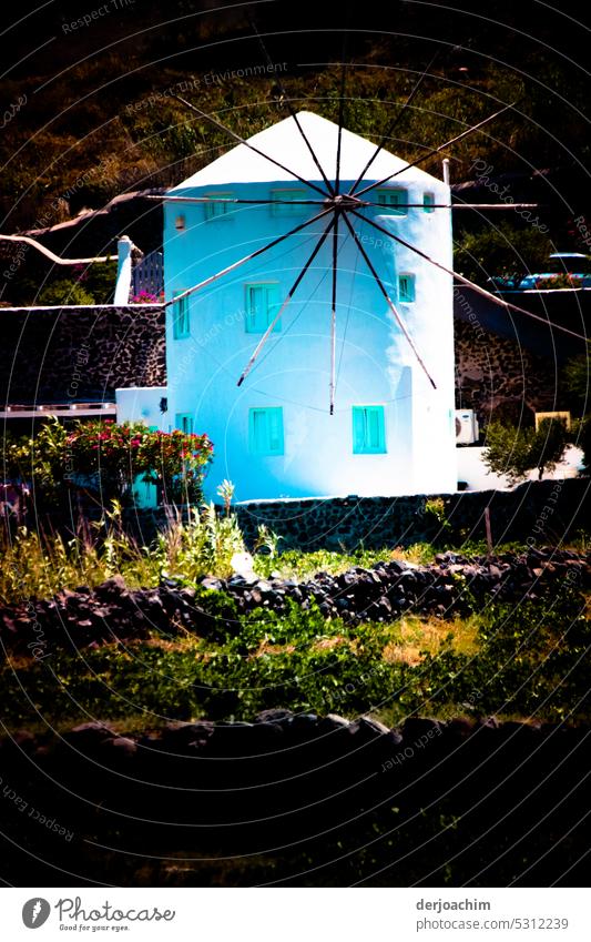Wunderschöne im hellen Sonnenschein eine Griechische Windmühle in Santorini. Flügel Energie grün Kraft nachhaltig Umwelt Erzeuger regenerativ