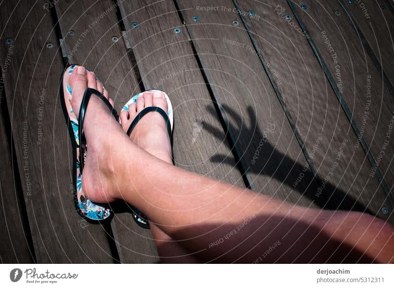 Zwei Nackte Füße in Sandalen im Sonnenschein mit einem Handschatten. nackte Füße Fuß Sommer Beine Barfuß Haut Außenaufnahme Erholung Zehen feminin Farbfoto