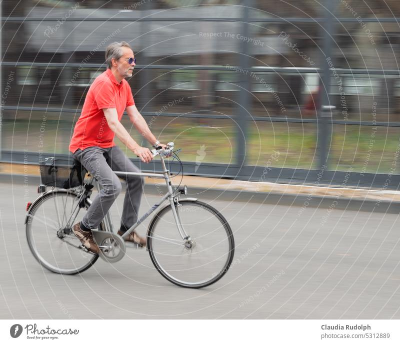 Grauhaariger Herr mit dem Fahrrad dynamisch unterwegs in der Stadt Best Ager Fahrradfahren Klimaschutz Verkehrswende Radfahren Verkehrsmittel Nachhaltigkeit