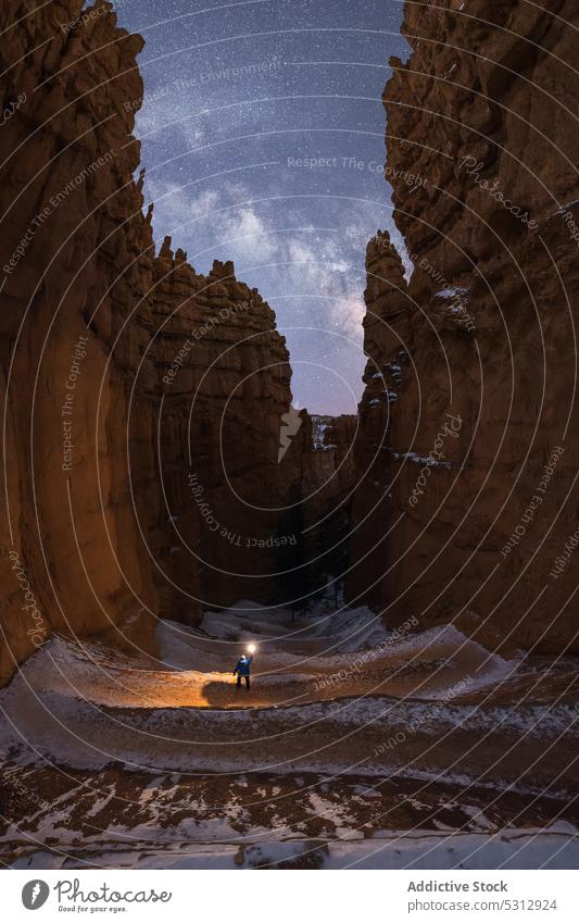 Anonymer Tourist, der nachts in einem Wüstental spazieren geht Reisender Taschenlampe Schlucht Berge u. Gebirge Natur Nacht Felsen bewundern Fernweh Wanderung