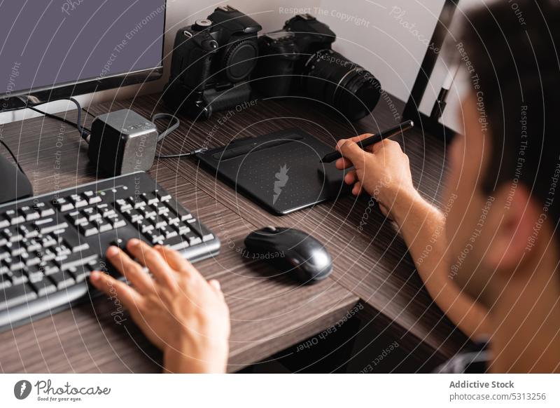 Crop-Mann bei der Arbeit an Computer und Grafiktablett Retusche Fotograf Fotoapparat graphisch Tablette Apparatur Keyboard benutzend Fotografie zeichnen