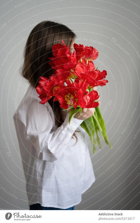 Unbekannte Frau mit einem Strauß Amaryllisblüten stehend Blume Flora Pflanze Blüte Blütezeit Vorbau Konzept geblümt filigran frisch rot Angebot romantisch jung