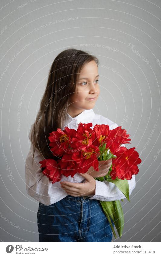 Mädchen stehend mit roten Tulpen im Zimmer Blume Blütezeit Freude zeigen Blumenstrauß Kind Vorschein Glück jung expressiv präsentieren Haufen Stil Frau Pflanze