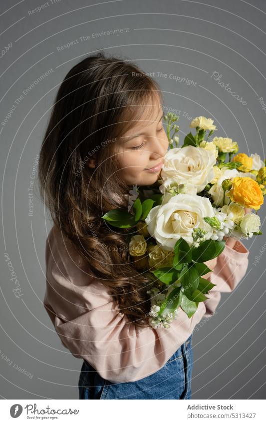 Preteen Girl riecht an einem Blumenstrauß Mädchen riechen geblümt Aroma Blütezeit Flora Augen geschlossen Kind Haufen natürlich Frau lässig präsentieren