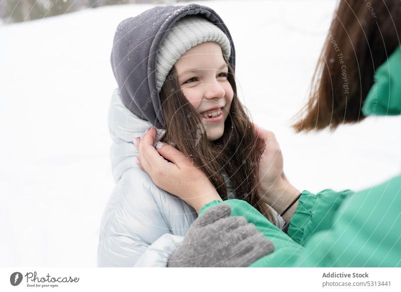 Anonyme Mutter mit Tochter, die sich in verschneiter Natur vergnügen Frau Mädchen Umarmen ausrichten Umarmung Winter Kinderbetreuung Park Verschlussdeckel