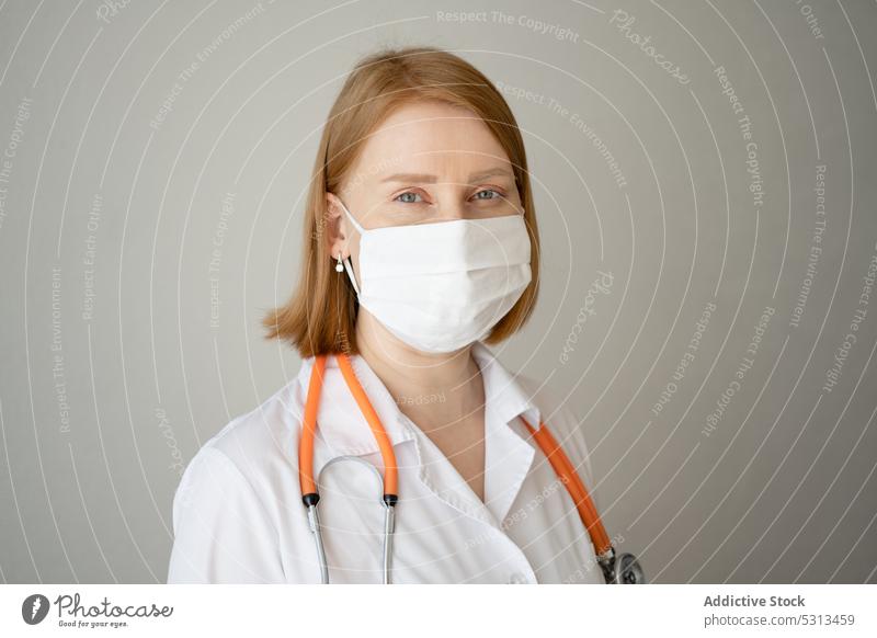 Frau mit medizinischer Maske, stehend mit Stethoskop Arzt Uniform Sanitäter Mundschutz verhindern Vorsicht Porträt professionell behüten Spezialist