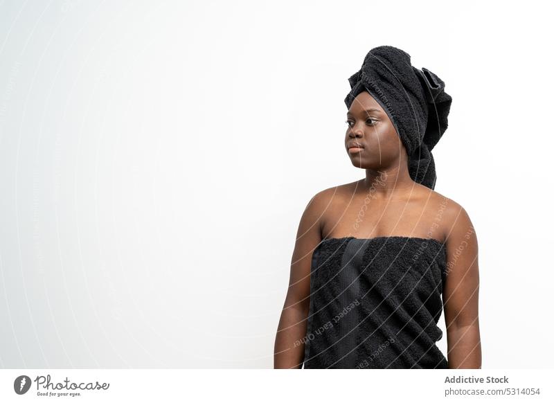 Ruhige schwarze Frau in Handtuch gewickelt umhüllen Dusche Bad Fokus Verfahren Hygiene Spa Sauberkeit jung ethnisch Wellness Pflege Windstille natürlich stehen