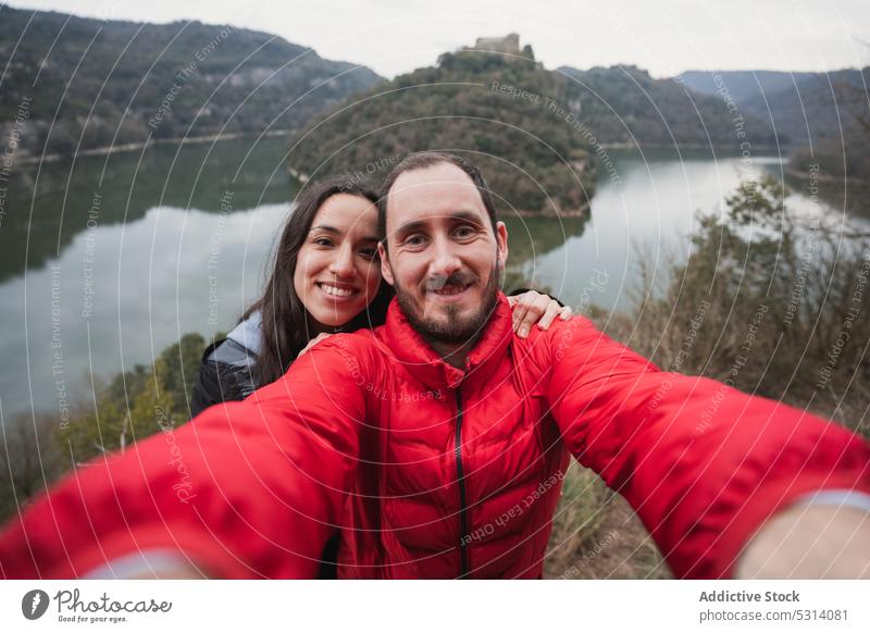 Glückliches Paar macht Selfie am Seeufer Berge u. Gebirge Wanderung Lächeln Natur Zusammensein Liebe Trekking Wanderer reisen Reisender heiter warme Kleidung