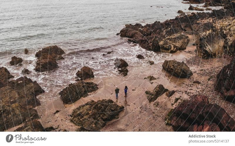 Drohnenansicht eines unerkennbaren Reisenden am felsigen Meeresufer Menschen Strand MEER Meereslandschaft Tourist Klippe Sand Wasser Republik Irland malerisch
