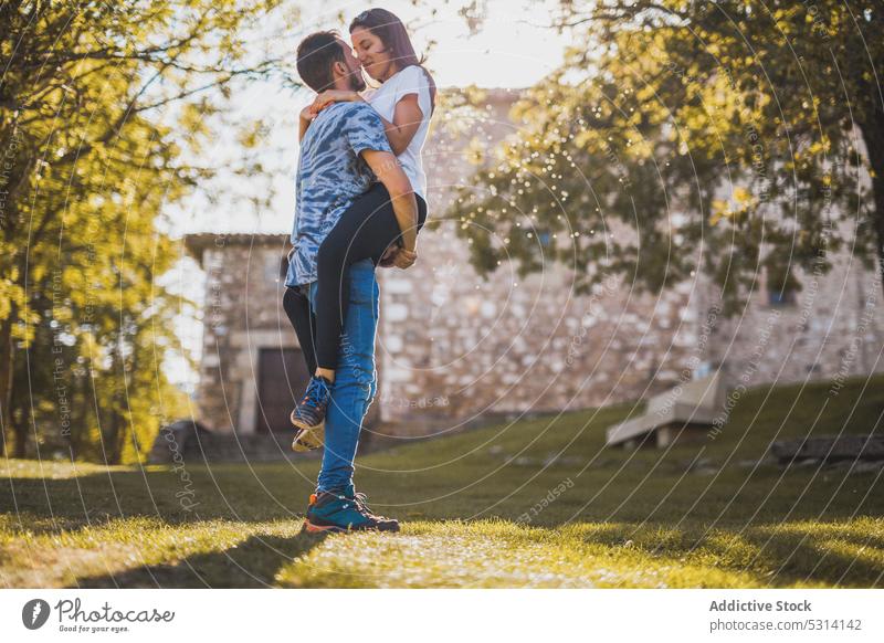 Mann trägt Freundin im Park an einem sonnigen Tag Paar Liebe Berührungsnase romantisch führen Partnerschaft Termin & Datum Sonnenlicht Baum Soria Spanien Europa