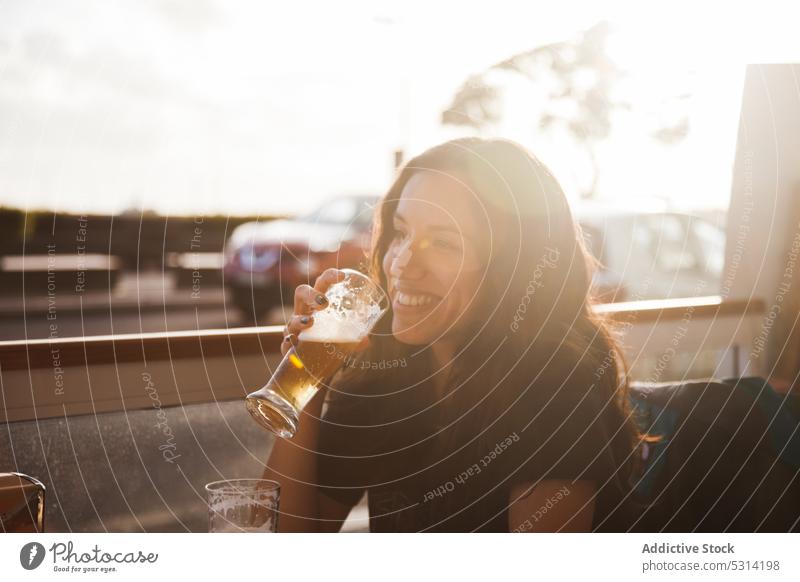 Glückliche Frau trinkt Bier in einem Cafe trinken Café Lächeln positiv Straße lässig Getränk Portugal heiter jung ruhen genießen sich[Akk] entspannen Lifestyle