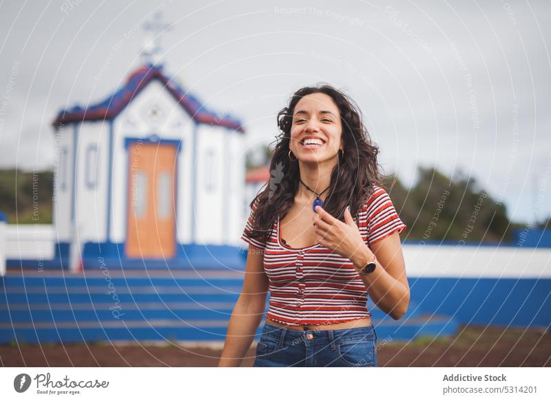 Fröhliche junge Frau lächelt mit geschlossenen Augen Glück Kirche Landschaft Gebäude Lächeln Hügel heiter Natur lässig Religion Azoren Portugal positiv