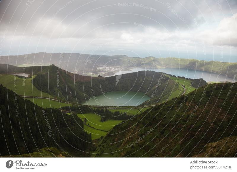 Malerische Aussicht auf ein grünes Tal am Bergrücken mit Wald und See Straße Landschaft Grasland Hügel Gelände Feld malerisch Umwelt Azoren Portugal Natur