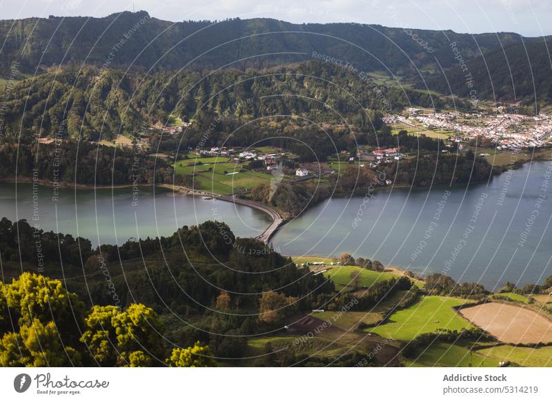 Malerischer Blick auf einen Fluss in einem grünen Tal mit Wald und Wohnsiedlung See malerisch Hügel Landschaft Natur Dorf Wasser ländlich Antenne Azoren