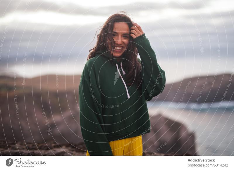 Glückliche Frau mit Blick auf die Kamera an einem bewölkten Tag MEER Strand Küste Ufer Lächeln heiter jung in die Kamera schauen Urlaub Azoren Portugal