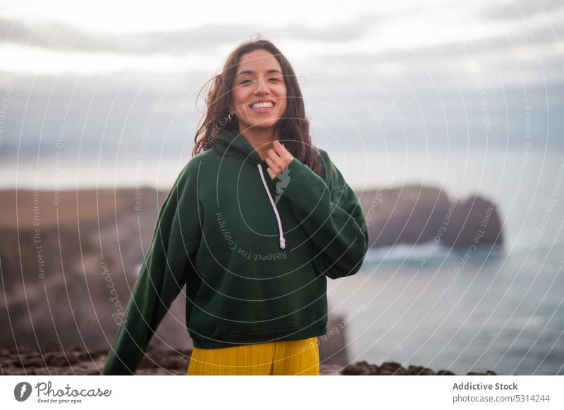 Glückliche Frau mit Blick auf die Kamera an einem bewölkten Tag MEER Strand Küste Ufer Lächeln heiter jung in die Kamera schauen Urlaub Azoren Portugal