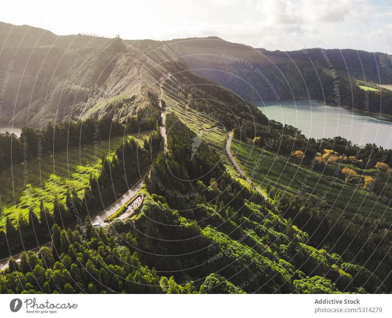 Erstaunliche Landschaft eines Bergrückens mit Fahrbahn in der Nähe eines Sees Berge u. Gebirge Kamm Sonnenlicht Baum wolkig malerisch Azoren Insel Portugal