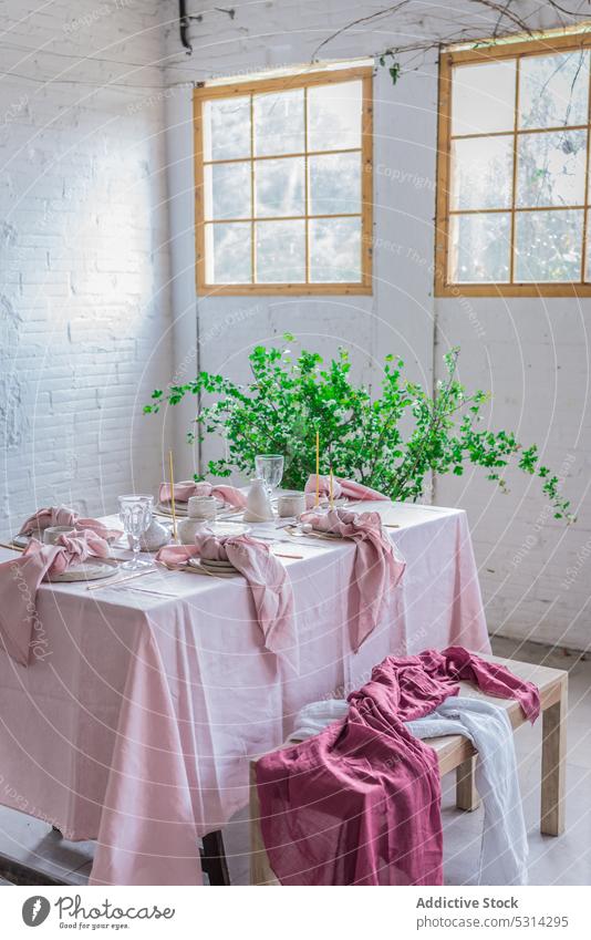 Esstisch mit Serviette und Bank Tisch Tischwäsche Backsteinwand eingetopft Geschirr Pflanze Blume kreativ Gewebe Stil rosa Fenster niedlich Stoff Dekor