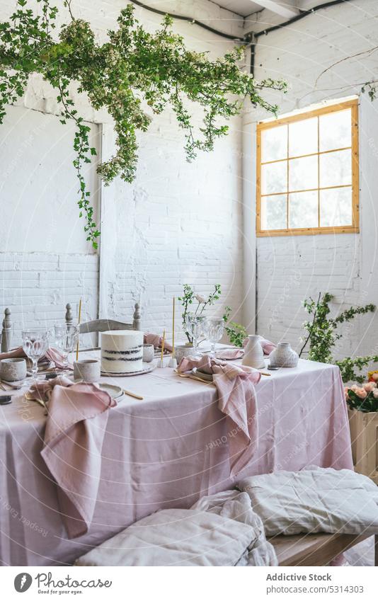 Banketttisch mit verschiedenem Geschirr und leckerem Kuchen Tisch Tischwäsche Backsteinwand eingetopft Pflanze Blume kreativ Gewebe Stil rosa niedlich Stoff
