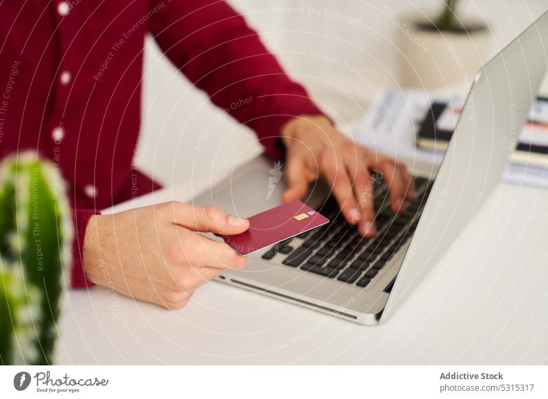 Anonymer Mann mit Kreditkarte benutzt Laptop zu Hause online Werkstatt Kauf bezahlen benutzend e-Commerce Käufer abgelegen männlich heimwärts Internet Zahlung