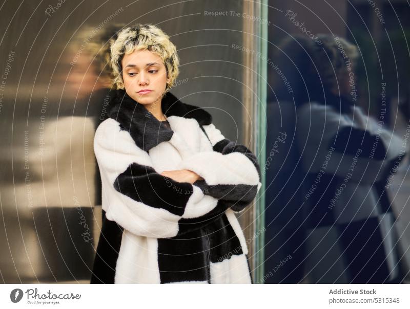 Verträumte Frau im Pelzmantel auf der Straße Stil fettarm Wand Mode besinnlich nachdenklich Mantel Fell urban trendy Outfit Gebäude Vorschein verträumt