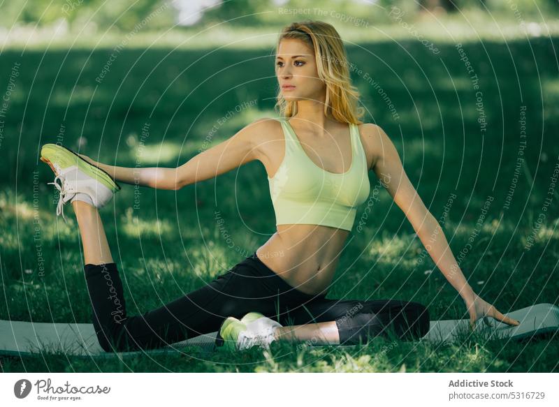 Junge Frau beim Sport im Park Training strecken Fitness Lifestyle jung Gesundheit Übung Athlet Sommer sonnig tagsüber Dame Wellness Wohlbefinden blond Körper