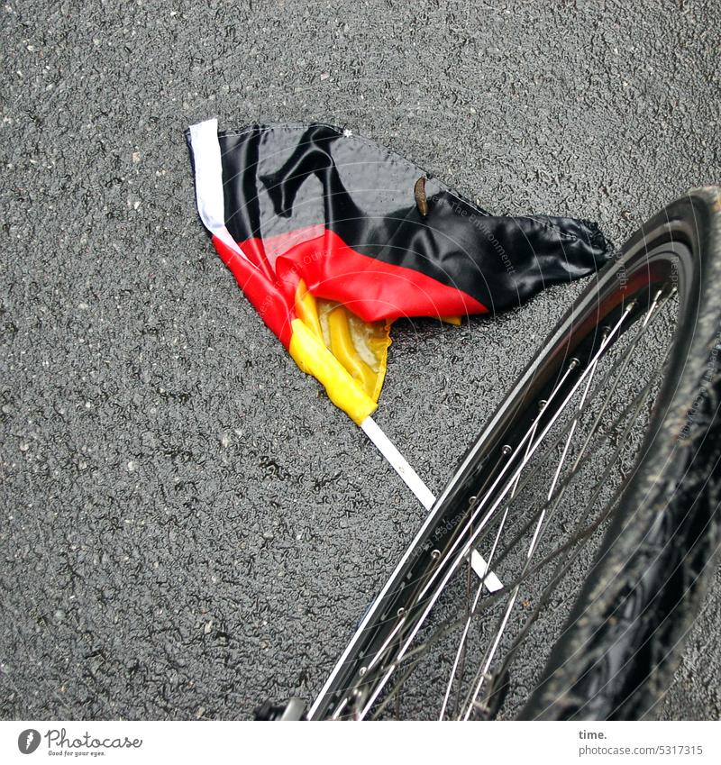 irgendwas mit Fußball Fahne Fähnchen Straße Fahrrad Asphalt Schnecke liegen nass weggeworfen Vogelperspektive Perspektive draußen unterwegs Deutschlandfarben