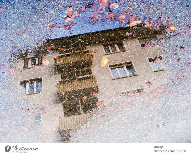 Haus in Pfütze Perspektive Reflexion & Spiegelung Wohnhaus nass wohnen grau Wolkenloser Himmel Blatt Wasser Fenster Balkon Mehrfamilienhaus Gebäude