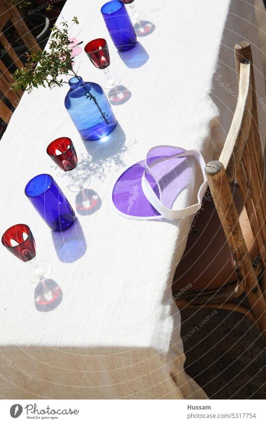 Foto eines Designkonzepts für einen Tisch mit bunten Flaschen und Gläsern und Spiegelungen liebevoll dekoriert Glas Tischdekoration Tischtücher für draußen
