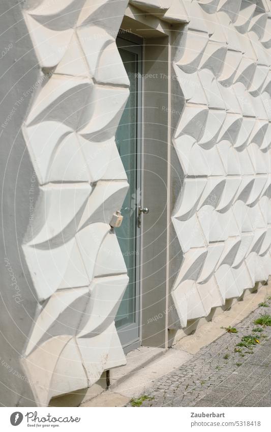 Weiße Fassade aus modernen Beton-Formteilen mit Tür formteil weiß eingang ausgang hell leer trist ddr architektur Gebäude Wand