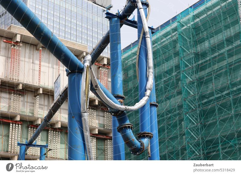 Blaue Entwässerungsrohre vor eingerüsteten Fassaden von Hochhäusern am Alexanderplatz Rohr blau kreuzend Baustelle Stadt Großstadt bauen renovieren Baugerüst