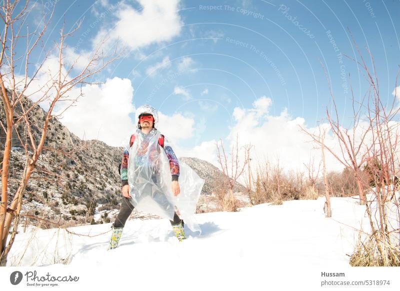 Foto über Superheld im Stehen im Schnee mit Liefersack Gewinner gewinnen Sieg super gelungen Erfolg stark im Freien so tun, als ob muskulös Mundschutz