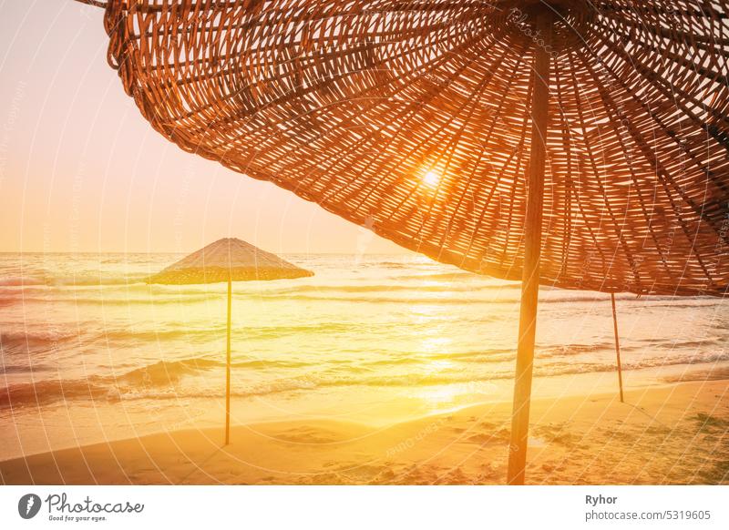 Wicker Beach Umbrella At Mediterranean Resort. Urlaub Konzept. Werbung Reiseunternehmen. Strand Sonnenschirm auf idyllischen tropischen Sandstrand. Konzept für Ruhe, Entspannung, Urlaub, Spa, Resort Design