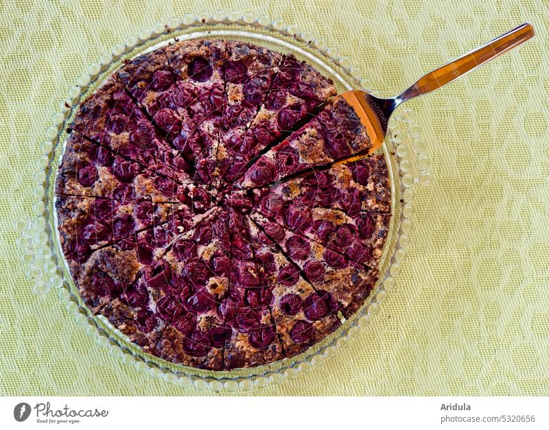 Kirsch-Schokokuchen auf einer Glasplatte mit Tortenheber auf blassgrünem Untergrund Kuchen Backen Kirsche lecker Oma süß genießen sündigen fruchtig Essen